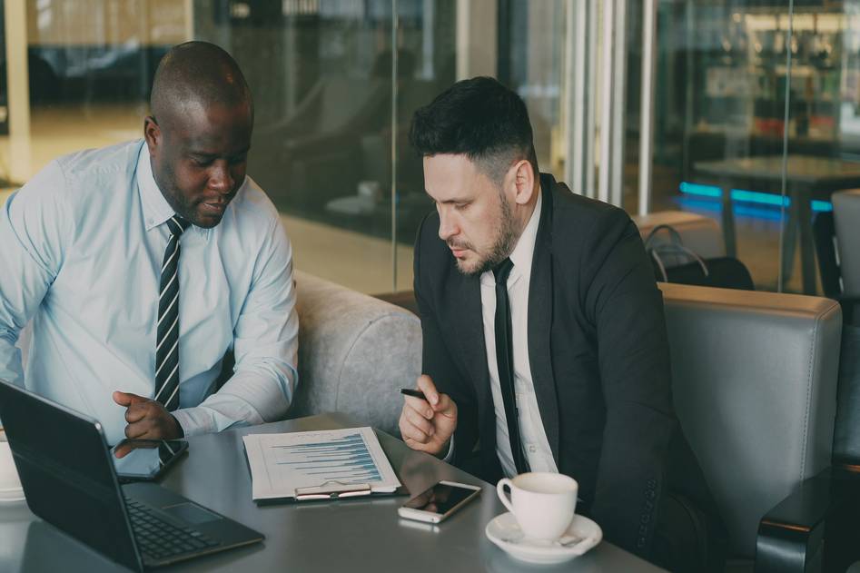 Diverse group of people discussing personal finance on laptops and phones